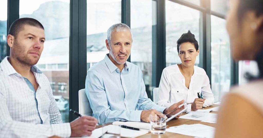 Three people having a discussion at a workplace